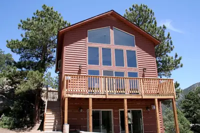 a cabin with a large window and a deck at Lazy R Cottages- 16A cabin in Estes Park