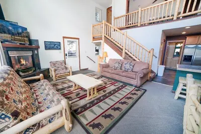 a living room with couches and a staircase at Lazy R Cottages- 16A cabin in Estes Park
