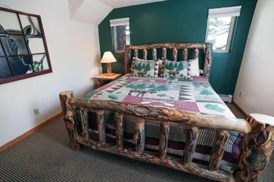a bedroom with a wooden bed with a wooden frame at Lazy R Cottages- 16A cabin in Estes Park