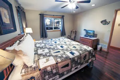 a bedroom with a bed and a ceiling fan at Sunnyside Knoll- 6 cabin in Estes Park