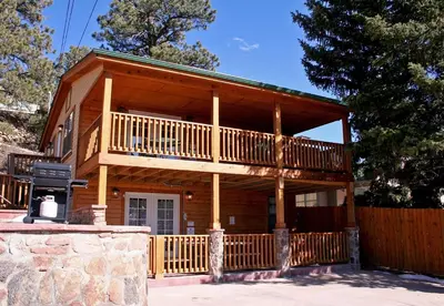 a large wooden cabin with a balcony and a fence at Lawn Lane B - #3383 in Estes Park