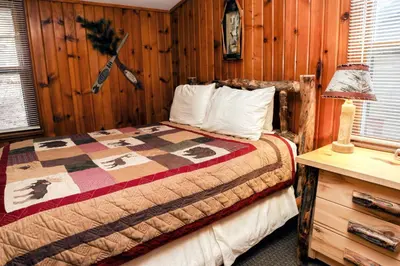a bedroom with a bed in a room with wooden walls at Lawn Lane B - #3383 in Estes Park