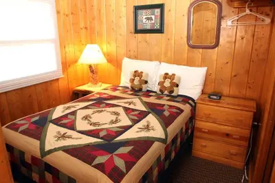 a bedroom with a bed with two teddy bears on it at Lazy R Cottages- 1 apts in Estes Park