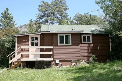 a small house on a hill with trees at Triple R Cottages- 5 cabin in Estes Park