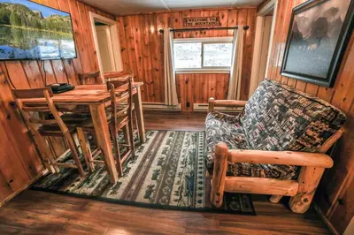 a living room with a table and a chair at Triple R Cottages- 5 cabin in Estes Park