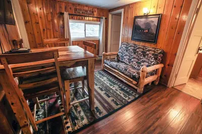 a living room with a table and a couch and a chair at Triple R Cottages- 5 cabin in Estes Park