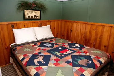 a bedroom with a bed with a quilt on it at Triple R Cottages- 5 cabin in Estes Park