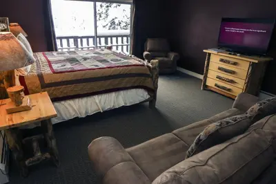 a living room with a bed and a couch and a tv at Fawn Valley Inn- 304 condo in Estes Park