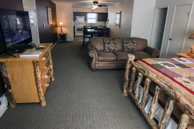 a living room with a bed and a couch and a television at Fawn Valley Inn- 304 condo in Estes Park