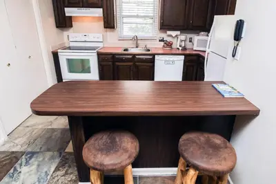 a kitchen with a wooden table and two stools at Fawn Valley Inn- 304 condo in Estes Park
