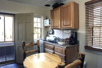 a kitchen with wooden cabinets and a wooden table at Triple R Cottages- 7 cabin in Estes Park