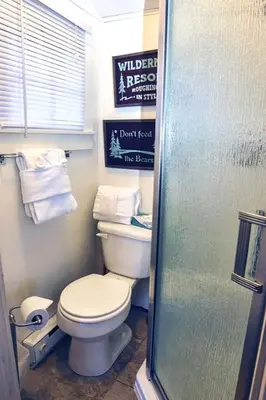 a small bathroom with a toilet and towels at Triple R Cottages- 7 cabin in Estes Park