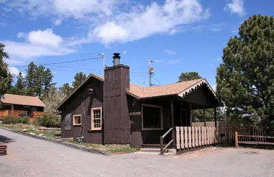 a small brown house with a chimney on a street at Lazy R Cottages- 2 cabin in Estes Park