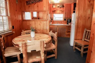 a kitchen with a table and chairs and a refrigerator at Lazy R Cottages- 2 cabin in Estes Park