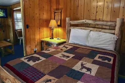 a bedroom with a bed with a quilt with animals on it at Lazy R Cottages- 2 cabin in Estes Park