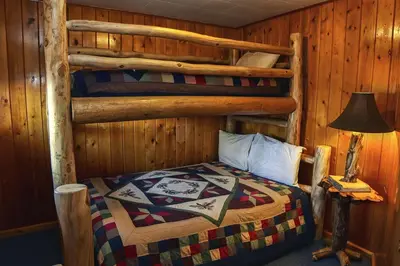 a bedroom with two bunk beds in a cabin at Lazy R Cottages- 2 cabin in Estes Park