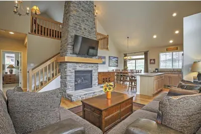 a living room with a fireplace and a dining room at Ski-In Granby Getaway in Granby