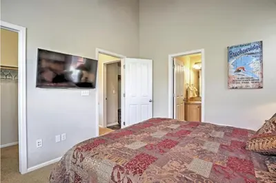 a bedroom with a bed and a tv on the wall at Ski-In Granby Getaway in Granby