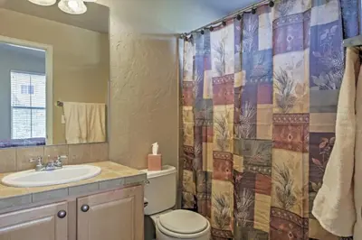 a bathroom with a sink and a toilet and a shower curtain at Ski-In Granby Getaway in Granby