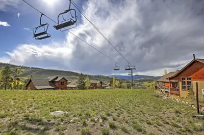 a gondola lift over a field with houses at Ski-In Granby Getaway in Granby