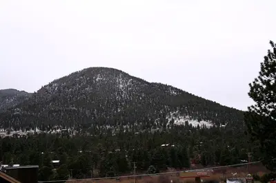 a mountain covered in trees in the distance at Lazy R Cottages- 7A cabin in Estes Park