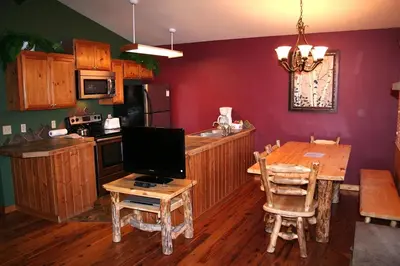 a kitchen with a wooden table and a dining room at Lazy R Cottages- 17 cabin in Estes Park