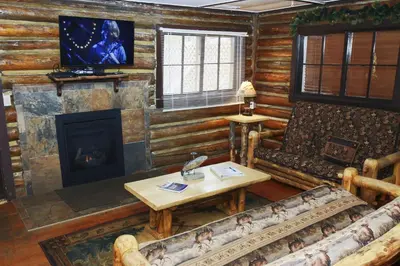 a living room with a couch and a fireplace at Triple R Cottages- 1 cabin in Estes Park