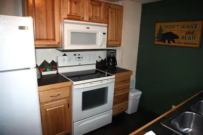 a kitchen with a white stove and a microwave at Triple R Cottages- 1 cabin in Estes Park