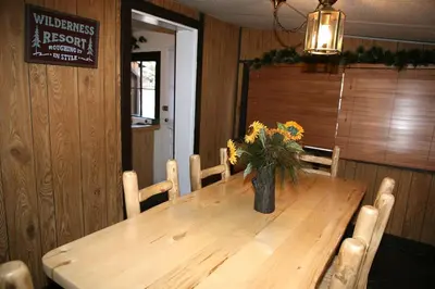 a wooden table with a vase of flowers on it at Triple R Cottages- 1 cabin in Estes Park