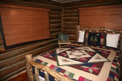 a bedroom with a bed in a log cabin at Triple R Cottages- 1 cabin in Estes Park