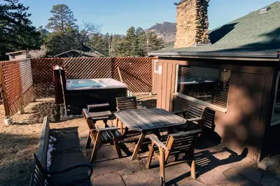 a patio with a table and chairs and a barbecue at Triple R Cottages- 1 cabin in Estes Park