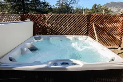 a hot tub in a backyard with a fence at Triple R Cottages- 1 cabin in Estes Park