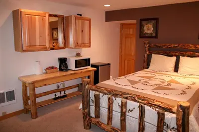 a bedroom with a bed and a microwave on a table at Fawn Valley Inn- 253 apts in Estes Park