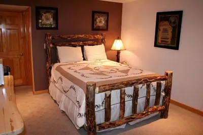 a bedroom with a wooden bed in a room at Fawn Valley Inn- 253 apts in Estes Park