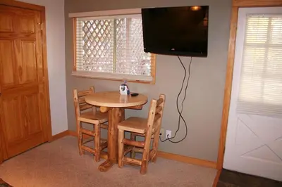 a small table and chairs in a room with a television at Fawn Valley Inn- 253 apts in Estes Park
