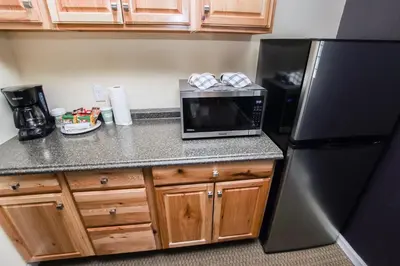 a kitchen with a black refrigerator and a microwave at Fawn Valley Inn- 294 condo in Estes Park