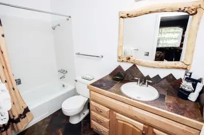 a bathroom with a sink and a toilet and a mirror at Fawn Valley Inn- 294 condo in Estes Park