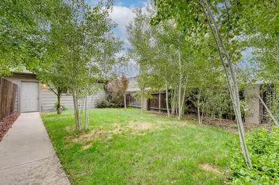 a house with a yard with trees and a driveway at 1 Mi to Dtwn Stylish Denver Home with Patio in Denver