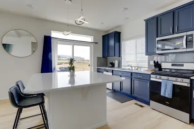 a kitchen with blue cabinets and a white counter top at 9 Mi to Airport Pet-Friendly Aurora Home with Deck in Aurora