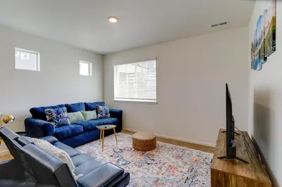 a living room with a blue couch and a tv at 9 Mi to Airport Pet-Friendly Aurora Home with Deck in Aurora