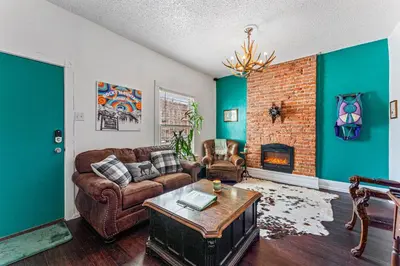 a living room with a couch and a fireplace at HOT TUB Firepit Pool Table Patio Cozy Downtown Denver in Denver