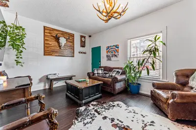 a living room with leather furniture and a chandelier at HOT TUB Firepit Pool Table Patio Cozy Downtown Denver in Denver