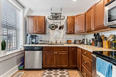 a kitchen with wooden cabinets and stainless steel appliances at HOT TUB Firepit Pool Table Patio Cozy Downtown Denver in Denver