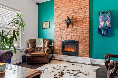 a living room with a brick wall and a fireplace at HOT TUB Firepit Pool Table Patio Cozy Downtown Denver in Denver