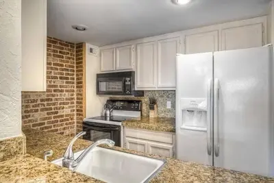 a kitchen with white cabinets and a white refrigerator at 2 BR Condo Heart of LoDo w/Great View/Amenities in Denver