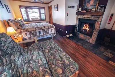 a living room with a couch and a fireplace at Sunnyside Knoll- 1 studio in Estes Park
