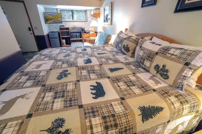 a bedroom with a bed with a quilt on it at Sunnyside Knoll- 1 studio in Estes Park