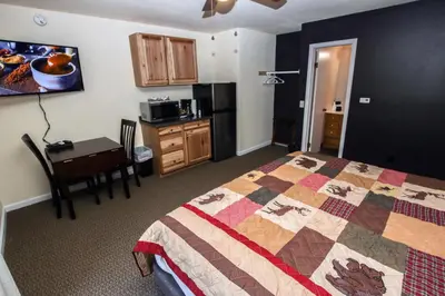 a bedroom with a bed and a table and a kitchen at Fawn Valley Inn- 293 condo in Estes Park