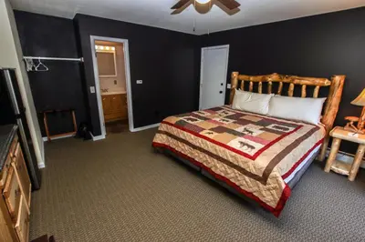 a bedroom with a large bed with a wooden headboard at Fawn Valley Inn- 293 condo in Estes Park