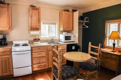 a kitchen with a table and a white stove top oven at Triple R Cottages- 4 cabin in Estes Park